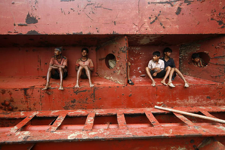 Workers rest after work at a ship breaking yard in Chittagong
